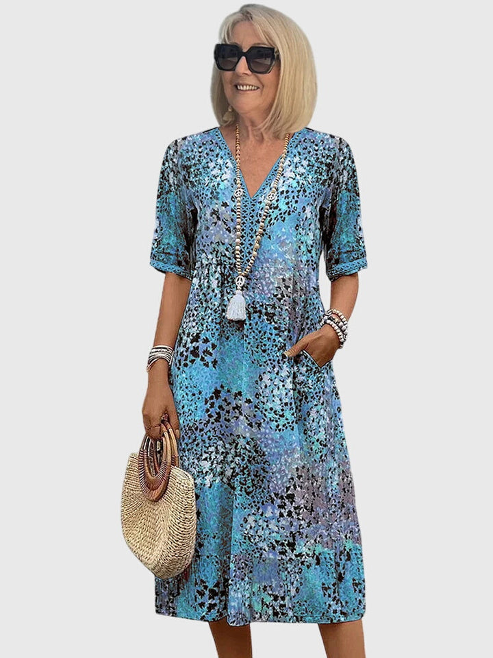 Casual elegante dames midi jurk met bloemenprint, V-hals en korte mouwen. Veelzijdige jurk met zakken voor dagelijks.