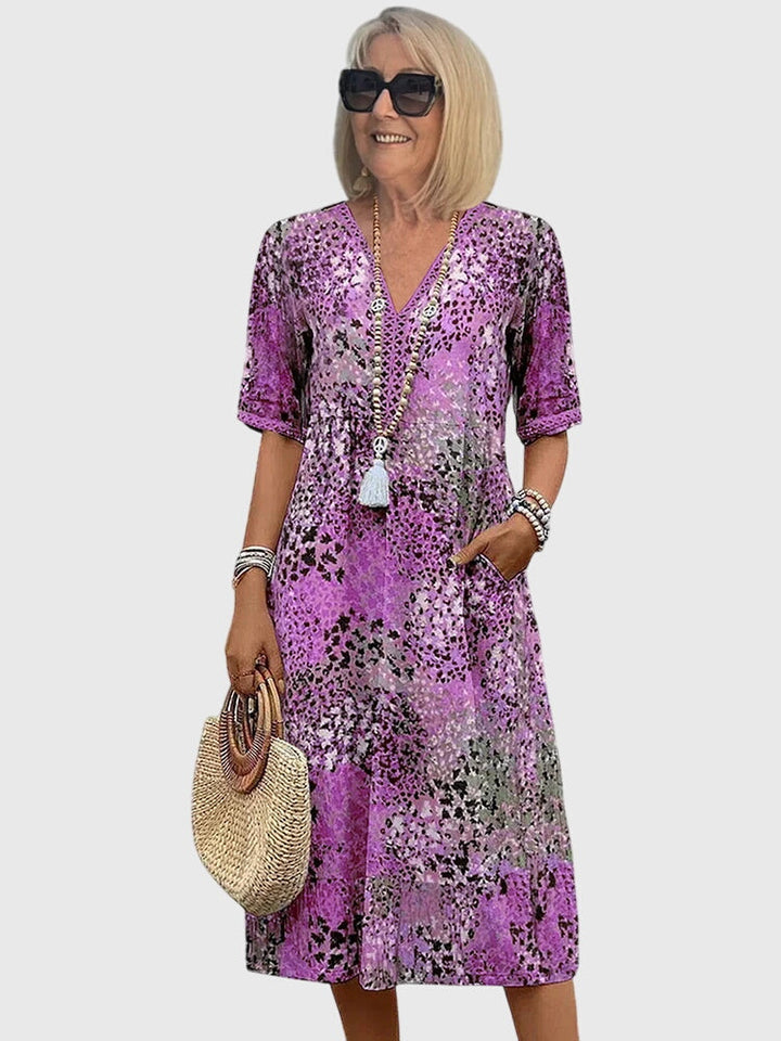 Luchtige dames midi jurk met vrolijke bloemenprint, V-hals en korte mouwen. Elegant en comfortabel voor lente/zomer.