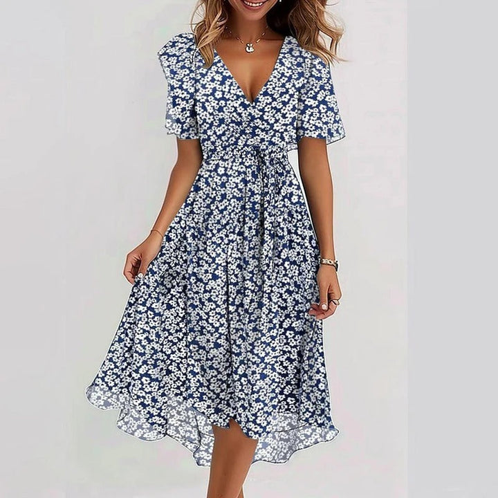 Feestelijke dames midi jurk met sierlijke vlindermouwen, diepe V-hals en een mooie bloemenprint. Met strikceintuur.