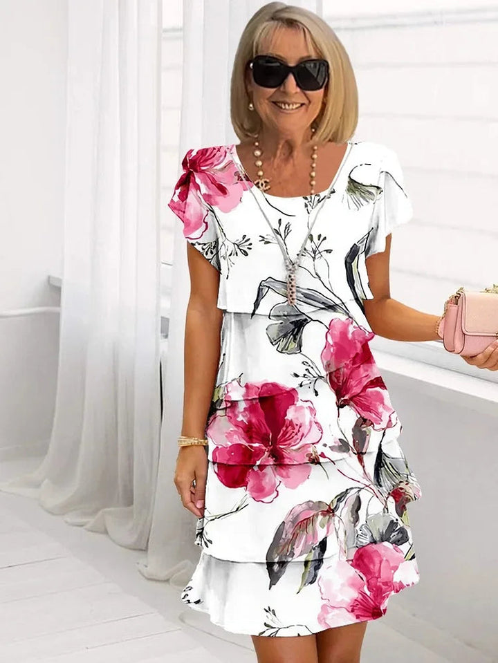 Elegante dames mini jurk met sierlijke ruffles en gelaagde stof, perfect voor zomerse dagen. Een stijlvolle trapeze jurk.
