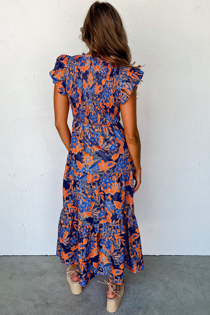 Blauwe dames maxi jurk met smocked lijfje en bloemenprint, ideaal als strandjurk of casual zomerjurk.