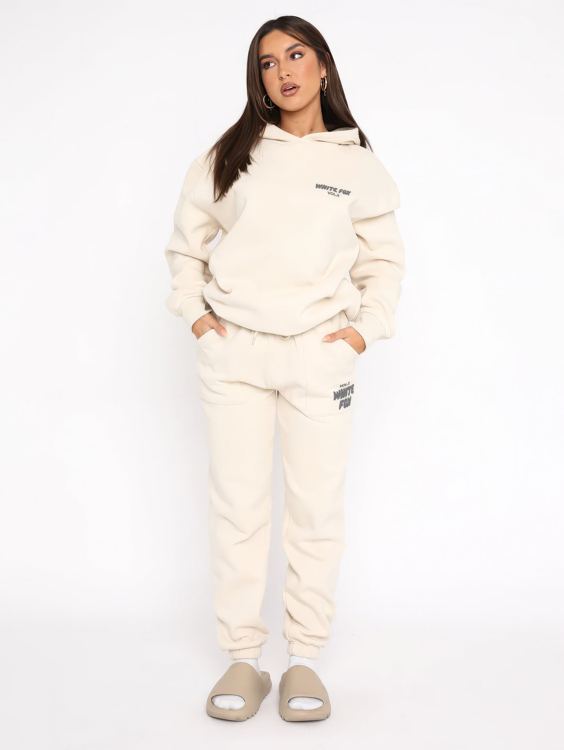 "Dames trainingspak met oversized pasvorm, wit, elastische ribboorden, trendy puffprint logo en fleecestof."