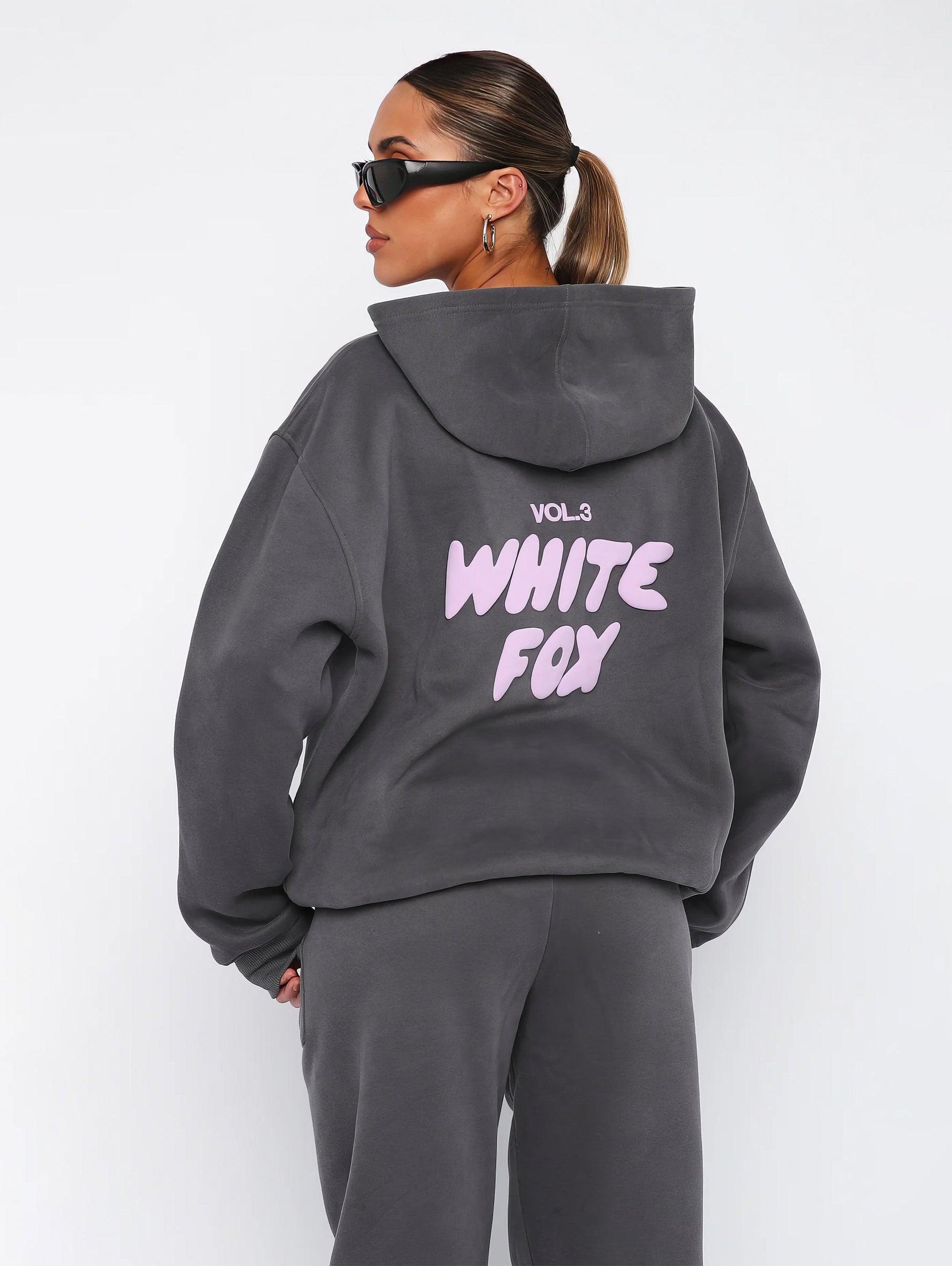 "Dames trainingspak met oversized pasvorm, wit, elastische ribboorden, trendy puffprint logo en fleecestof."