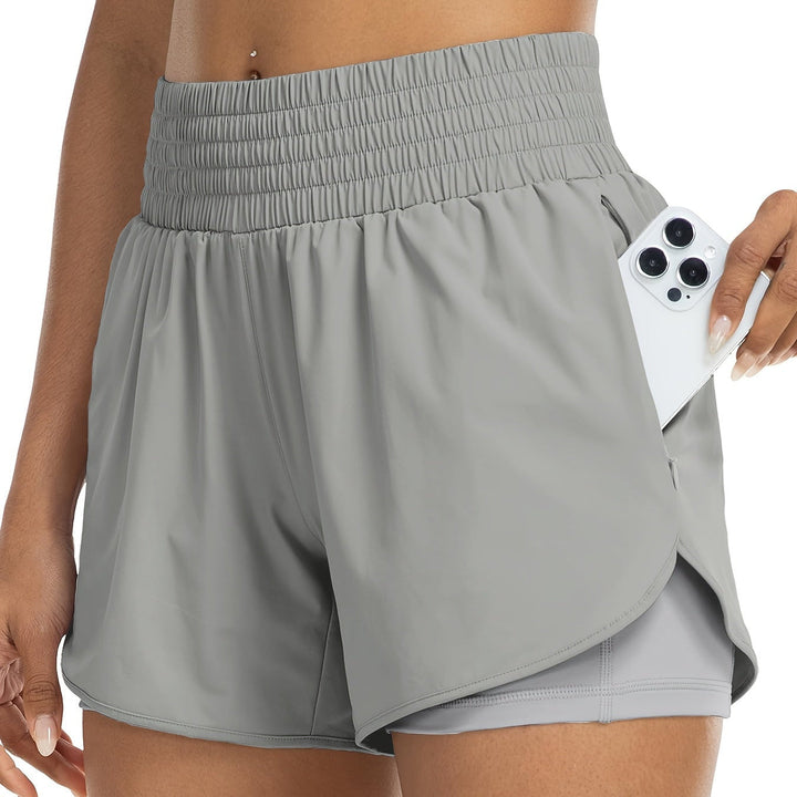 Vrouw draagt een sneldrogende dames sportshort met hoge taille tijdens een yogasessie.