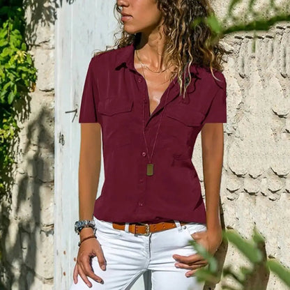 "Damesblouse Adelaide, elegante korte mouwen, klassieke kraag, handige borstzakken, luchtige polyester stof, blauwe kleur."