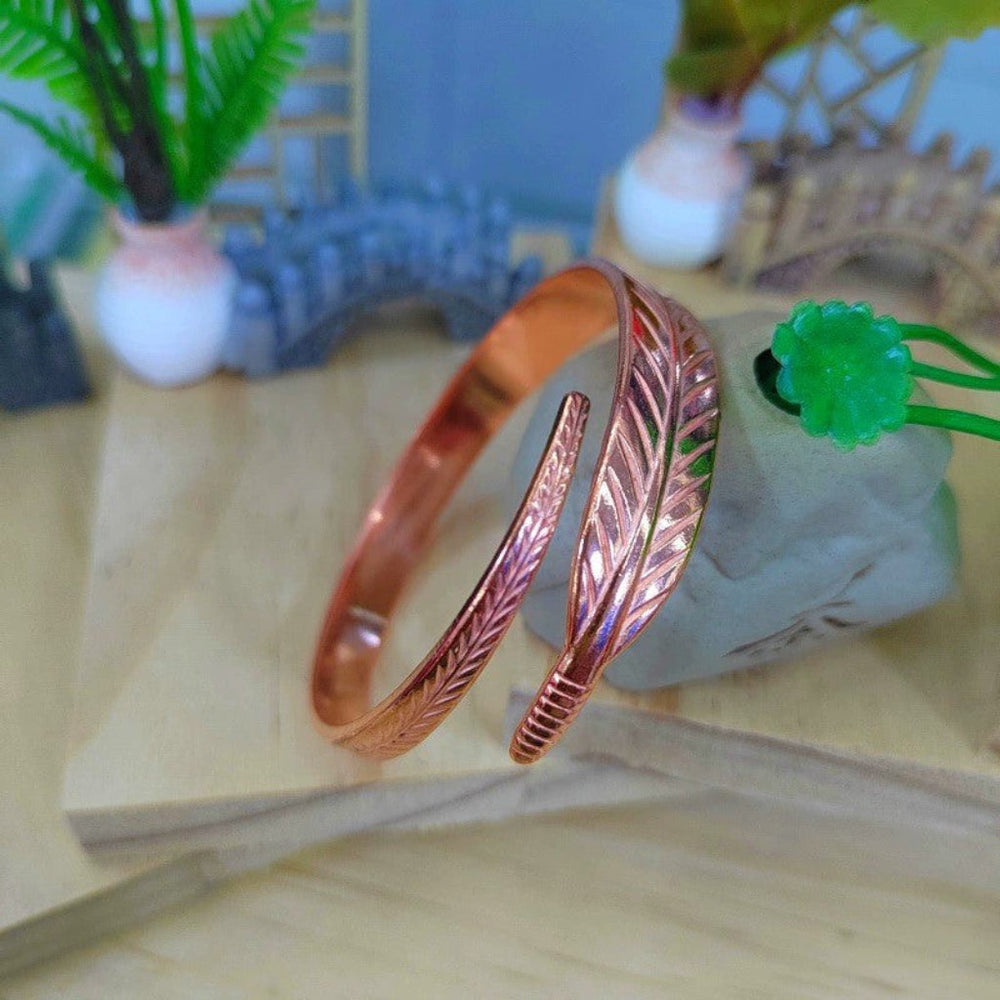Elegante dames armband van retro koper, met verfijnd bladmotief; een stijlvol vintage accessoire.