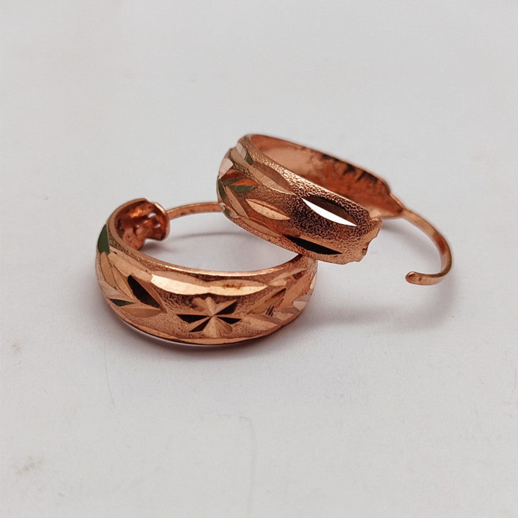 Getextureerde dames oorbellen van roségoud en koper, elegante sieraden voor een complete outfit.