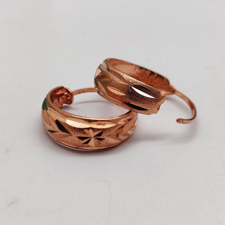 Getextureerde dames oorbellen van roségoud en koper, elegante sieraden voor een complete outfit.