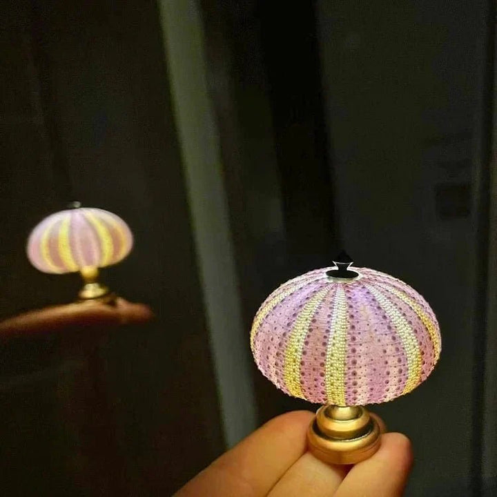 Handen knutselen aan het DIY LumiUrchin zee-egel nachtlampje. Een creatief project voor sfeervolle interieurdecoratie.
