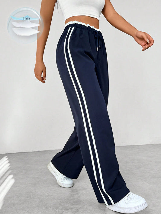 Donkerblauwe joggingbroek met witte strepen, elastische tailleband, sportief en trendy design, damesmode.