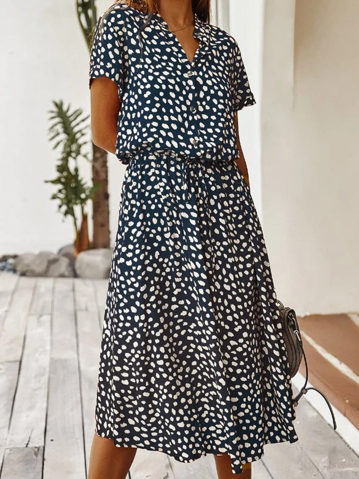 Model draagt comfortabele dames midi-zomerjurk met opvallende print, voorzijde.
