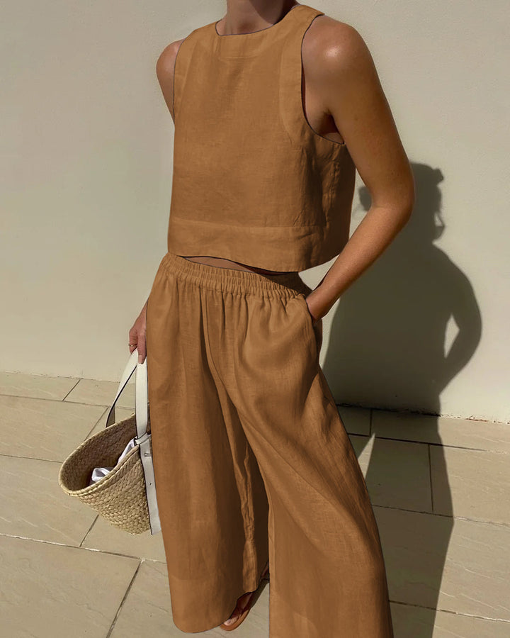 Zwarte dames tweedelige zomeroutfit met stijlvolle crop top en wijd pijpen broek. Modieus.
