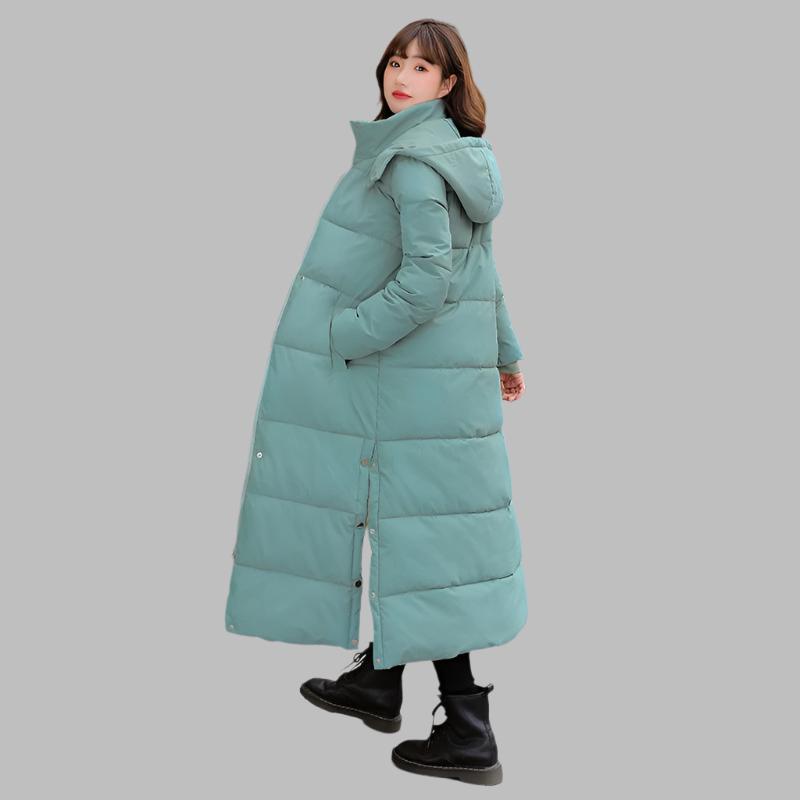 Dames model draagt warme gewatteerde midi winterjas; een trendy parka voor stijlvolle winterse outwear.