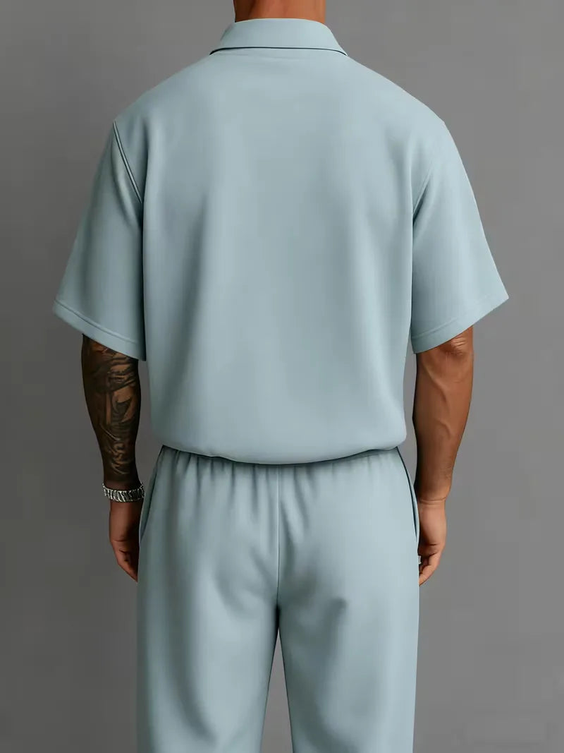 Modern heren smart-casual pak, polo met korte mouwen en rechte broek voor een relaxte look.