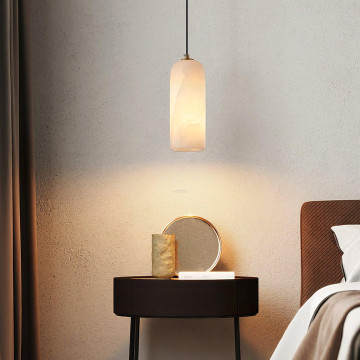 Design hanglamp in albast en messing, creëert warme sfeer in eethoek.
