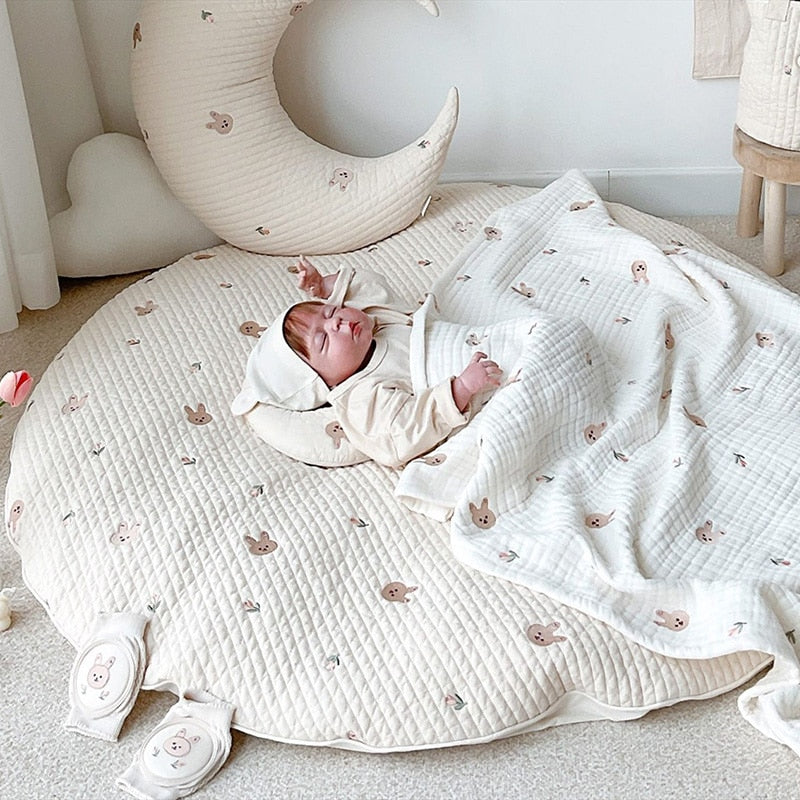 Ronde baby speelmat van katoen met schattig geborduurd dierenmotief, perfect voor de kinderkamer.
