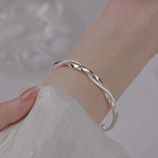 "Elegant gedraaide zilveren armband, verstelbaar, met gedetailleerd ontwerp. Perfect voor elke gelegenheid."