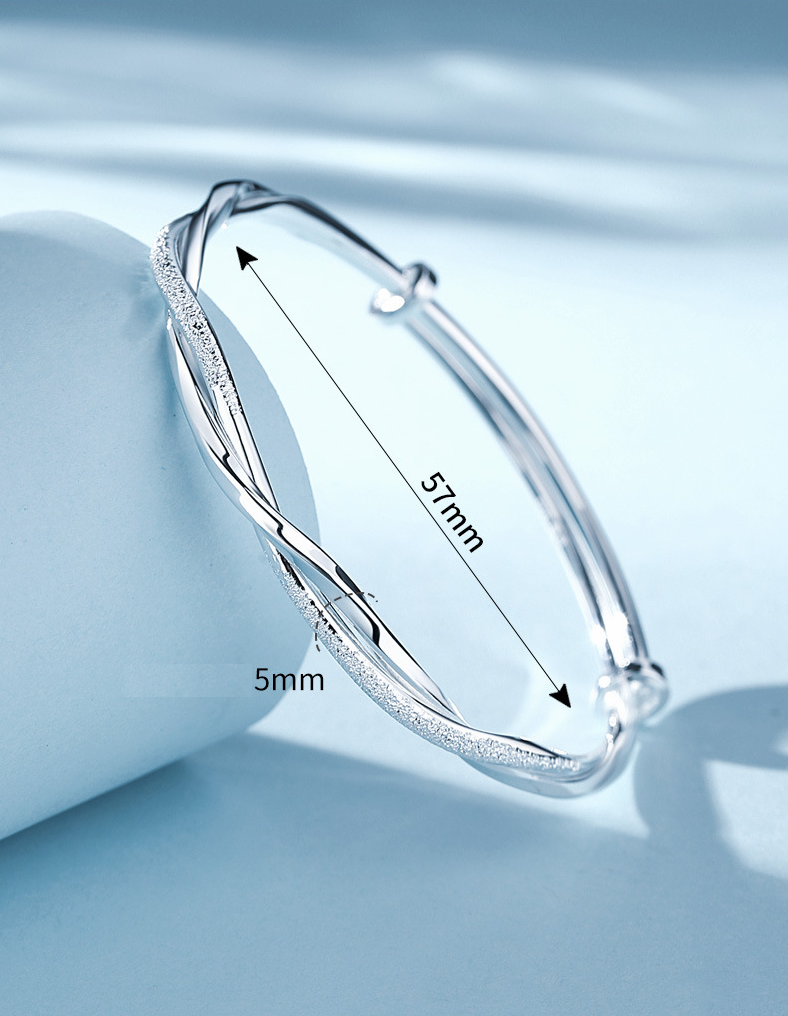 "Elegant gedraaide zilveren armband, verstelbaar, met gedetailleerd ontwerp. Perfect voor elke gelegenheid."
