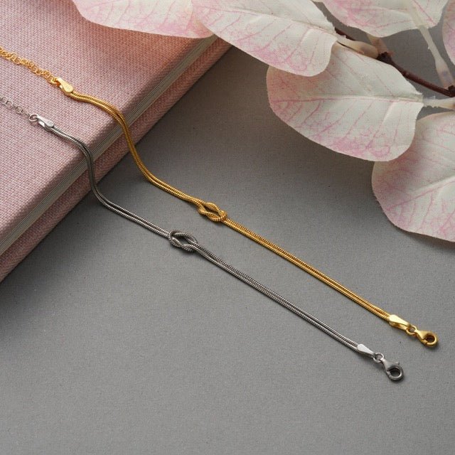 "Elegant gouden liefdesknoop armband voor dames, minimalistisch ontwerp, tijdloos en verfijnd accessoire."