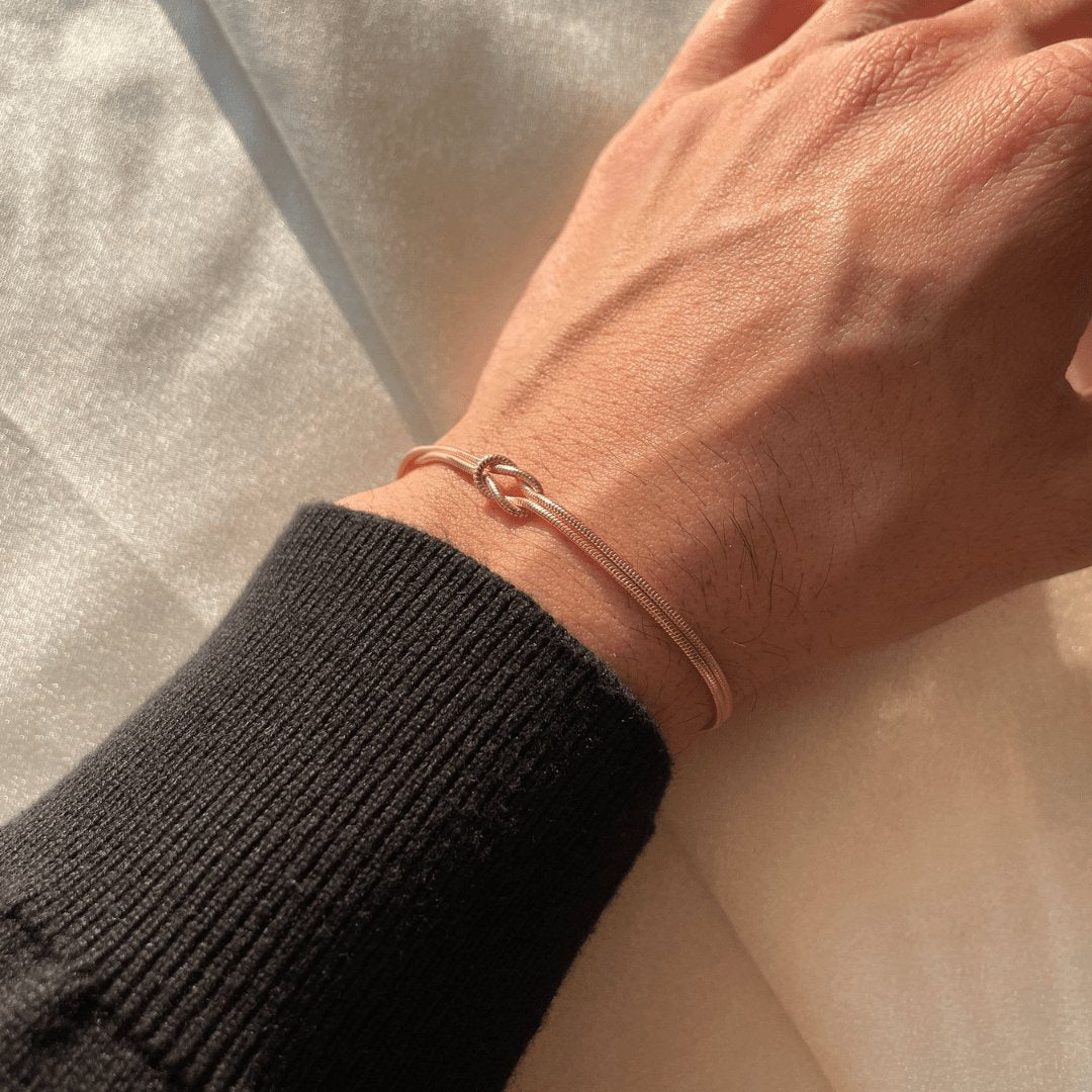 "Elegant gouden liefdesknoop armband voor dames, minimalistisch ontwerp, tijdloos en verfijnd accessoire."