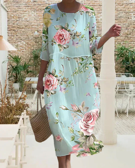 "Elegante bloemenprint midi jurk met losse pasvorm en subtiele mouwen, perfect voor casual en zomerse evenementen."
