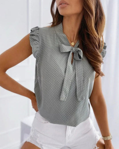 "Elegante Brianna damesblouse met polkadots, strikdetail en ruffles; luchtige zomertop voor veelzijdige stijl."