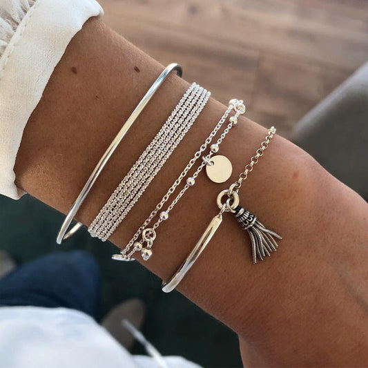 "Elegante gelaagde zilveren armbandenset met verfijnd ontwerp; chique, tijdloos accessoire voor vrouwen."