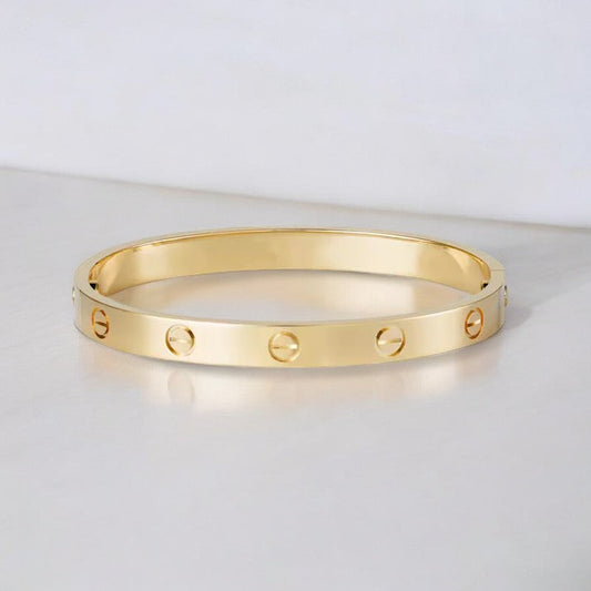 "Elegante gouden armband met tijdloos design en schroefdetails, een verfijnd en luxueus accessoire voor elke gelegenheid."