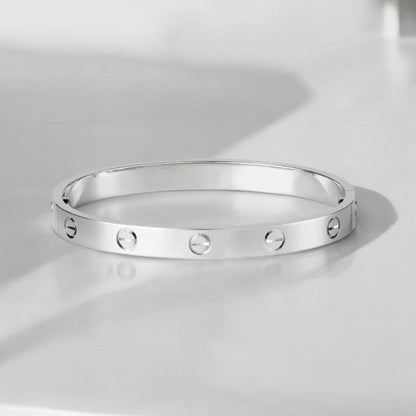 "Elegante gouden armband met tijdloos design en schroefdetails, een verfijnd en luxueus accessoire voor elke gelegenheid."