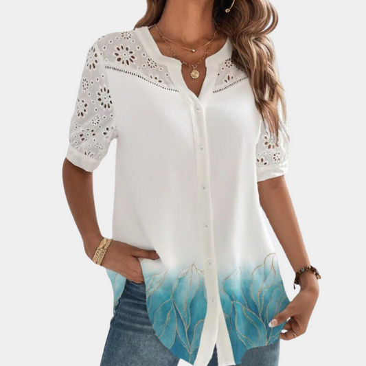 "Elegante lichtblauwe damestop met korte mouwen, kanten detail en losse pasvorm, ideaal voor zomerdagen."