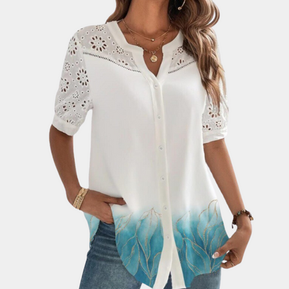 "Elegante lichtblauwe damestop met korte mouwen, kanten detail en losse pasvorm, ideaal voor zomerdagen."