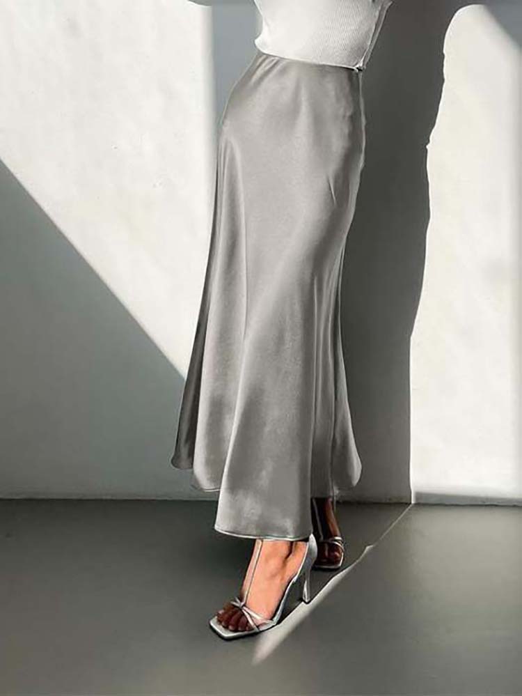 "Elegante satijnen midi-rok in vloeiende stijl, met subtiele glans en veelzijdige pasvorm voor moderne dames."