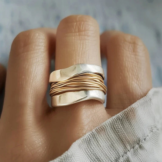 "Elegante zilver-gouden ring met gedraaid ontwerp, luxe uitstraling, symbool voor harmonie en stijl, ideaal cadeau."