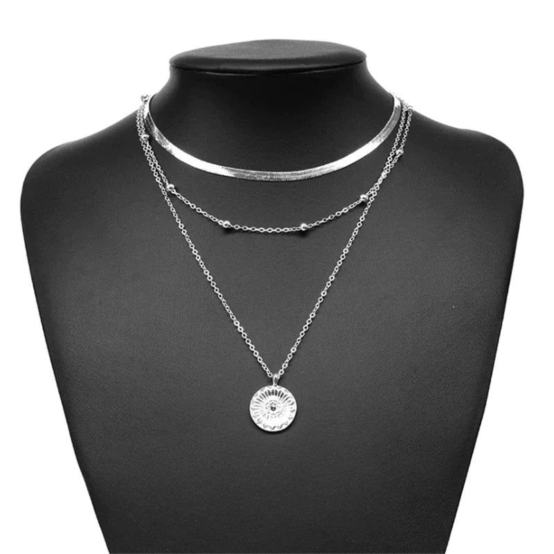 Detailopname van de fijne schakels van de zilveren drievoudige ketting. Glanzend sterling zilver sieraad.