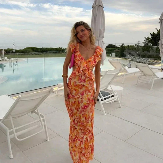 "Elegante zomerjurk met kleurrijke bloemenprint, ruffles en strikdetail, in tinten oranje, roze en geel, zomermode dames."