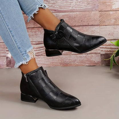 "Elegante zwarte enkellaarzen voor dames met lage hak, verfijnd klassiek design, ideaal voor formele gelegenheden."