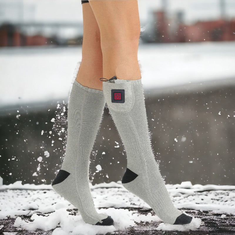 Vrouw draagt comfortabele grijze verwarmde sokken. Ideaal voor warme voeten tijdens outdoor activiteiten of koud weer.