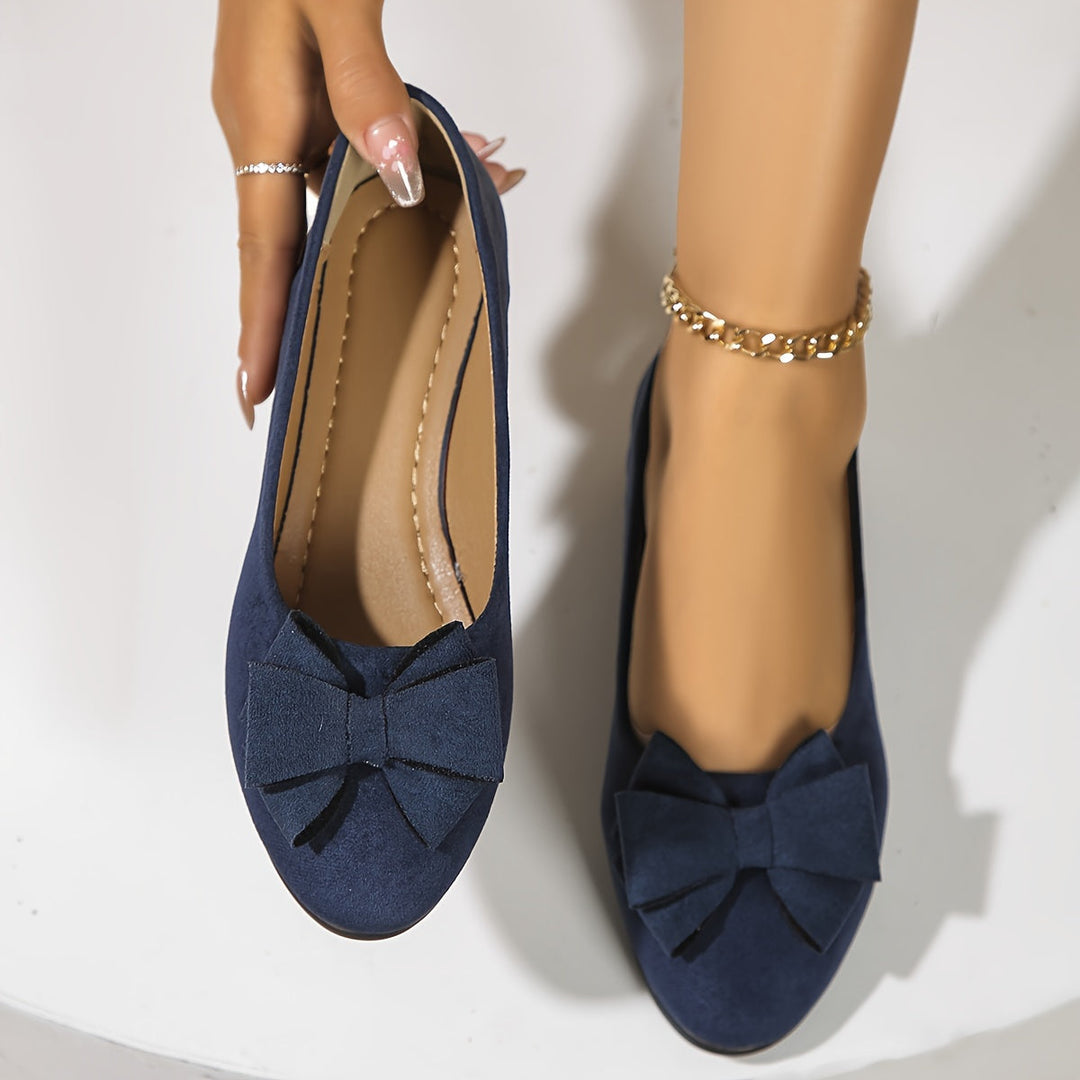 Close-up van de stijlvolle strik op elegante dames ballerina's met sleehak.