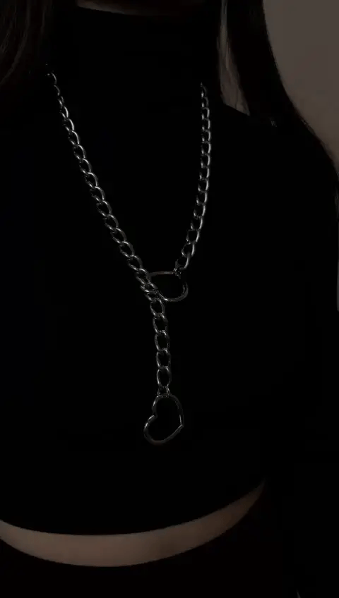 Detail van glanzende ketting met hartslot en bijpassende sleutel, symbool van eeuwige liefde.