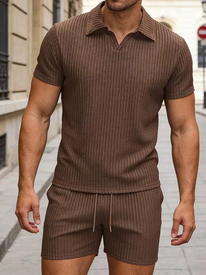 Model toont trendy heren tweedelige zomer outfit: moderne polo en shorts voor een complete casual look.