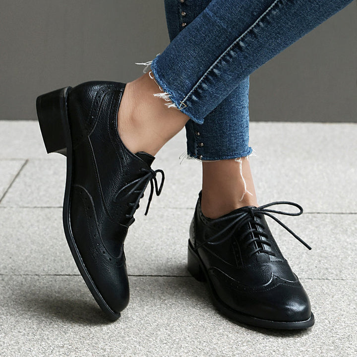 Formele damesmode: veterschoenen met lage hak en elegante perforaties, ideaal voor een professionele look.