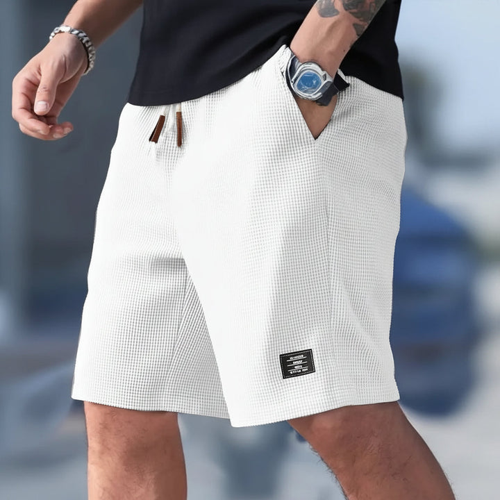 Basic heren wijde sportshort met trekkoord, zakken en relaxte pasvorm, onmisbaar voor zomer en sport.
