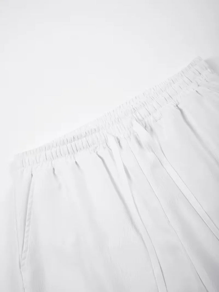 Witte heren plissé shorts met trekkoord en elastische tailleband, perfect voor strand en vakantie.
