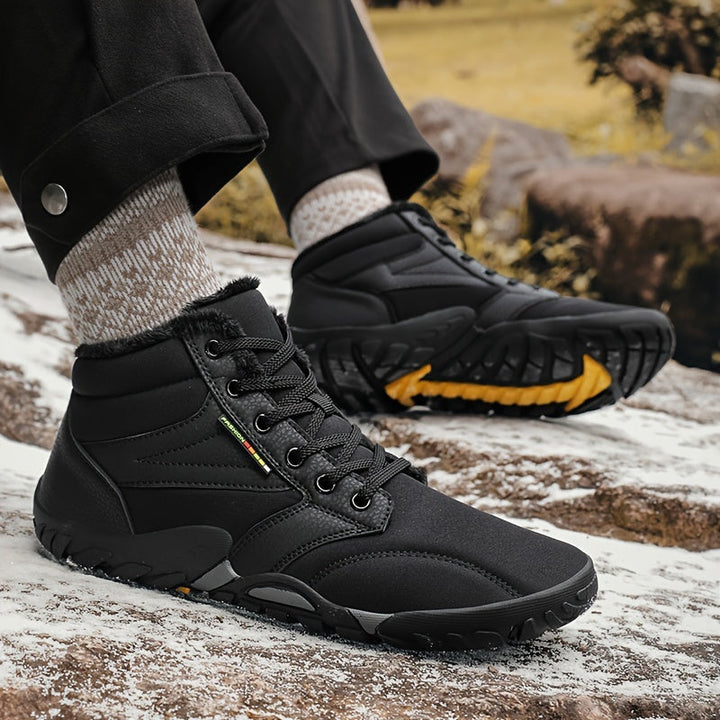 Een paar Heren Finn winterlaarzen, klaar voor de sneeuw, met warme voering en duurzame zolen voor comfort en grip.