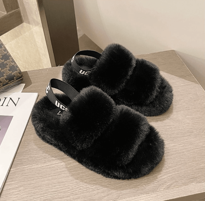 Vrouw draagt comfortabele Fluffy Flops™ winter slippers binnenshuis. Warme zachte dames pantoffels.