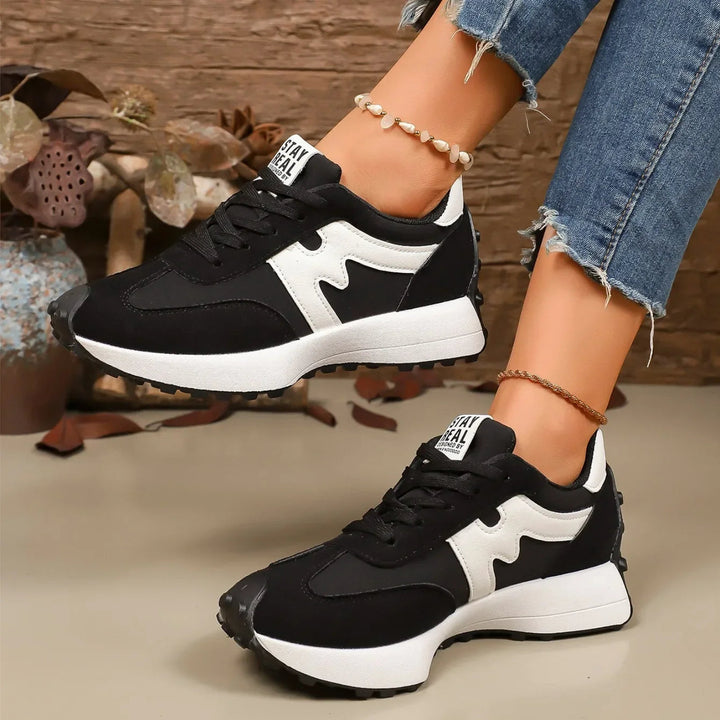 Zwarte dames platform vetersneakers met gestreepte details, comfortabel en modieus.