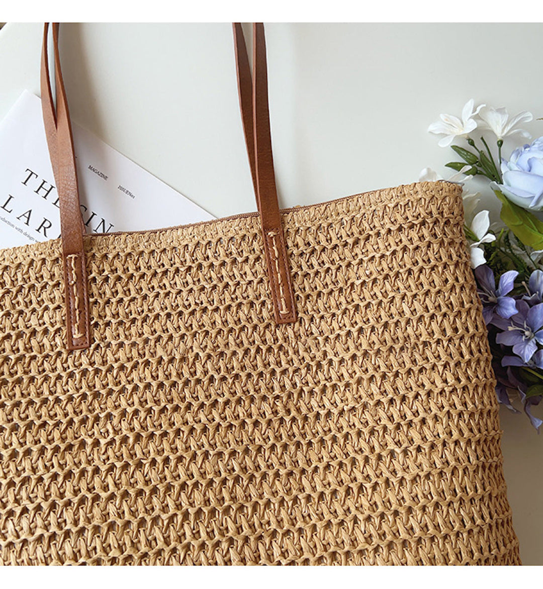 Stijlvolle geweven korbtas (bruin/wit) met comfortabele handvatten, perfect als strandtas.