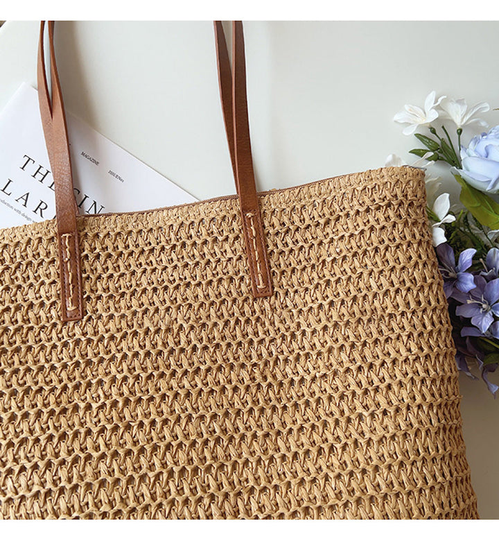 Stijlvolle geweven korbtas (bruin/wit) met comfortabele handvatten, perfect als strandtas.