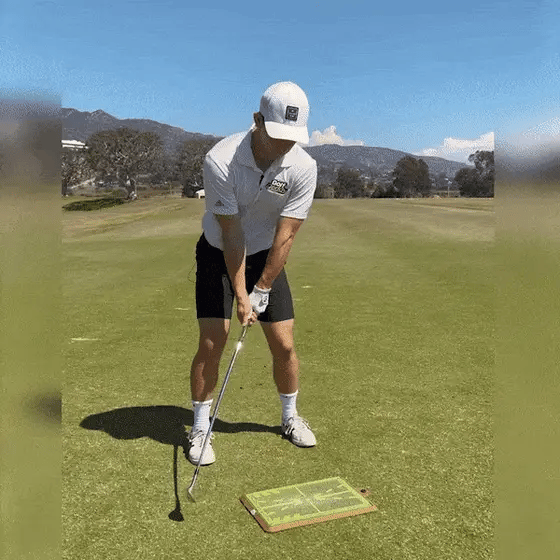 Golfer oefent swing op de golfslagmat, analyseert impact en swingpad voor betere golfprestaties.