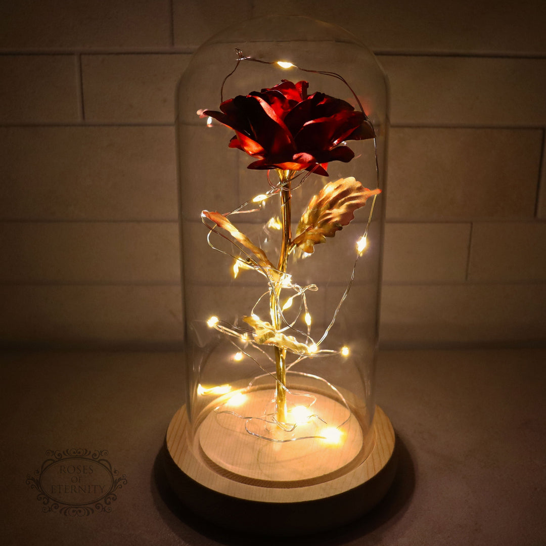 Eeuwige gouden roos met sfeervolle LED-verlichting onder een elegante glazen stolp, perfect cadeau.